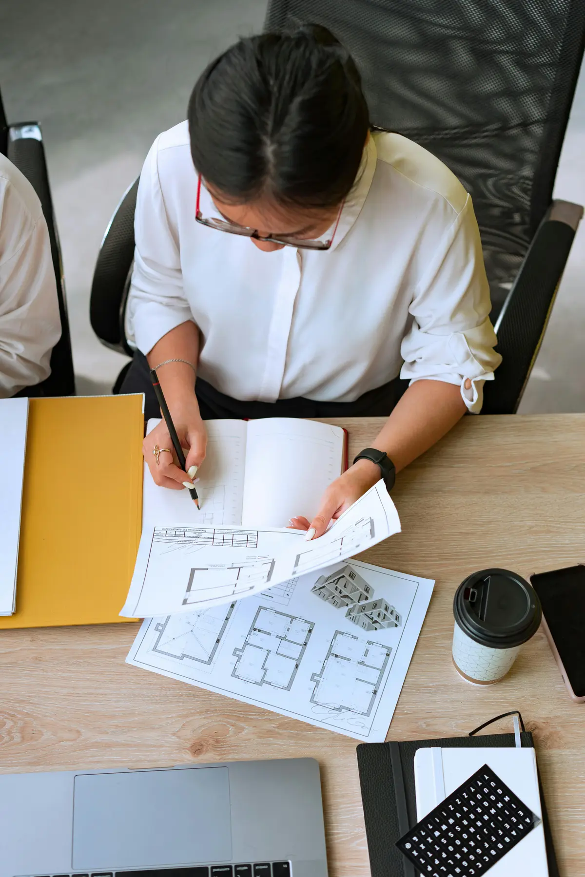 Arquitecta revisando planos y diseños arquitectónicos